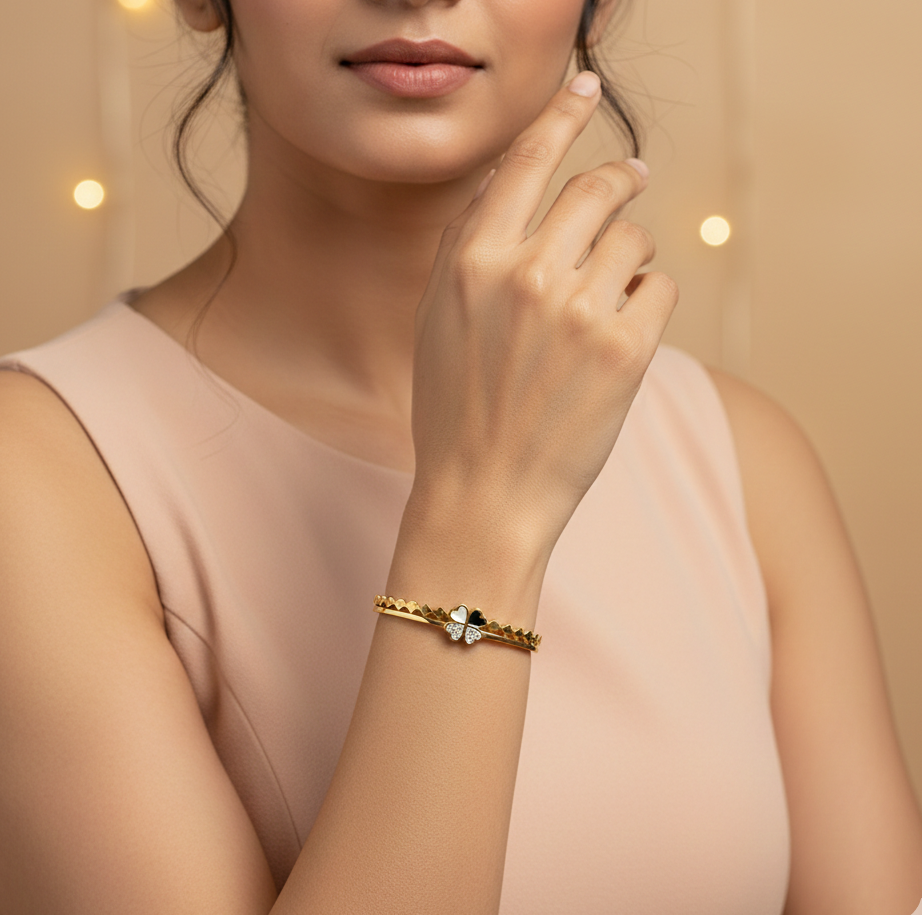Woman wearing a gold bracelet with a heart charm on a beige background