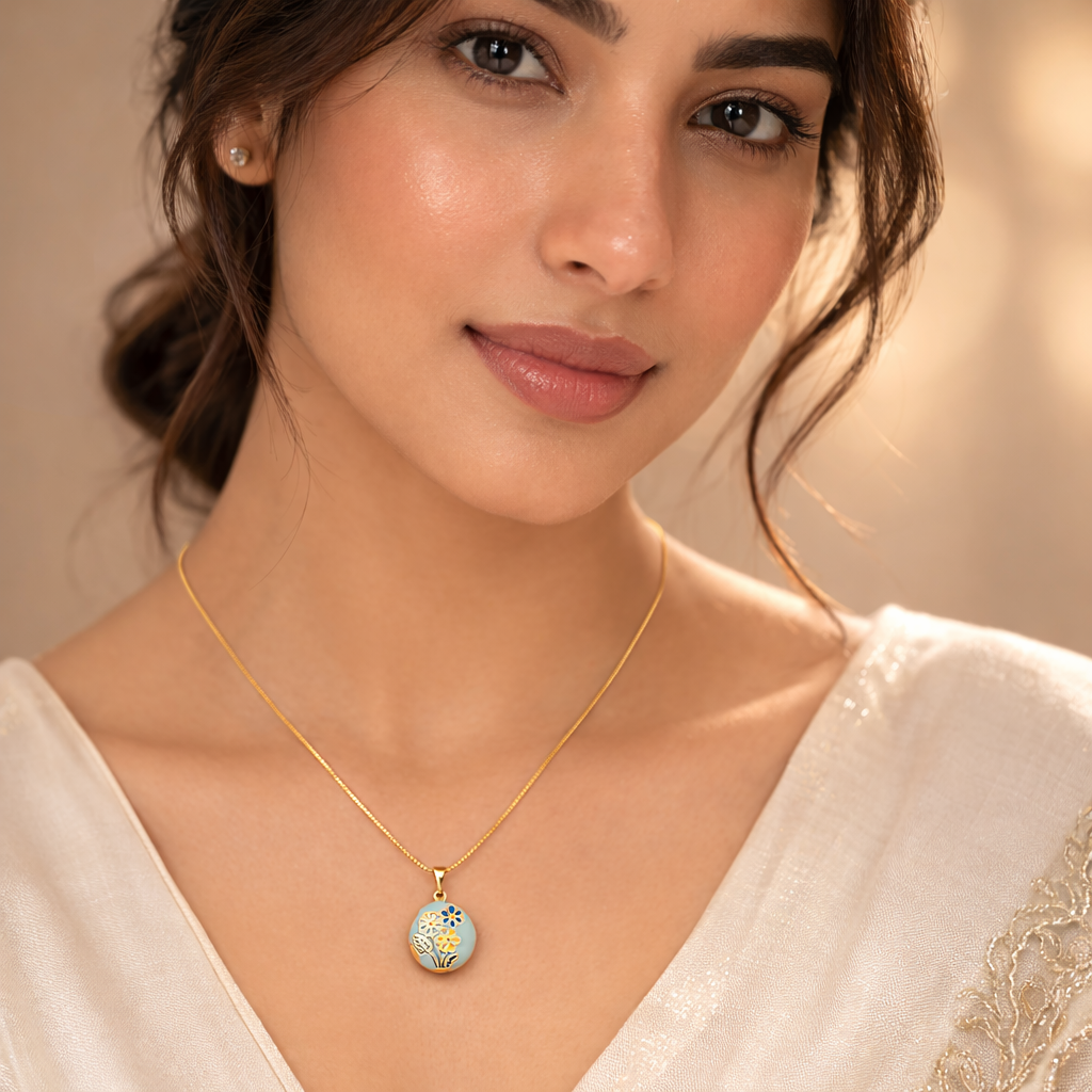 Woman wearing a gold necklace with a decorative pendant against a neutral background