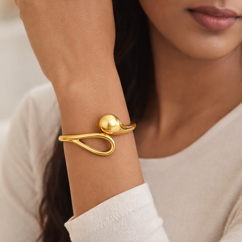 Gold bracelet on a wrist with a blurred background