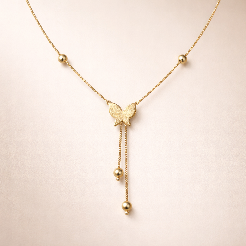 Gold necklace with a butterfly pendant on a light pink background