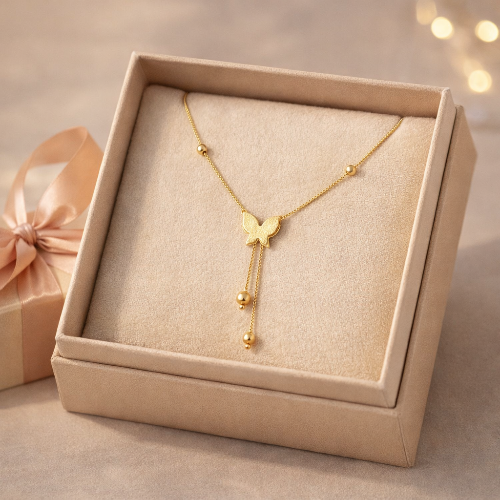 Gold necklace with a butterfly pendant in a beige jewelry box.