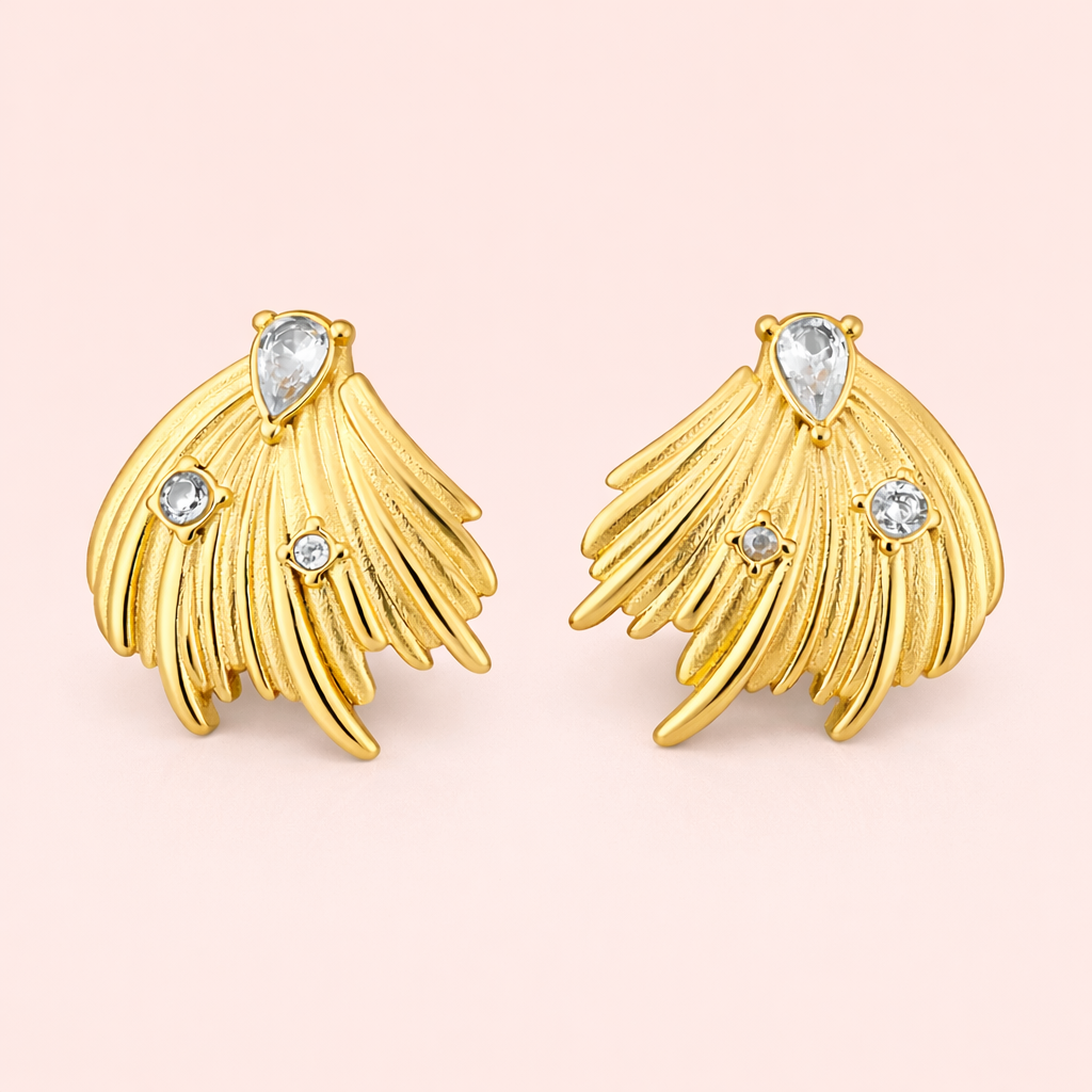 Gold plated feather inspired earrings for women displayed as a single product on clean soft blush background