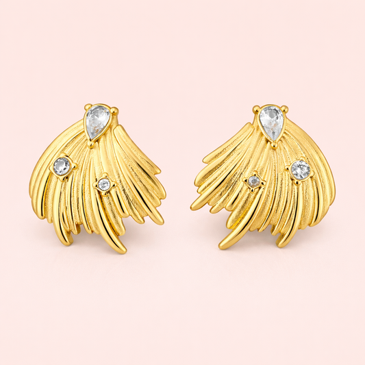 Gold plated feather inspired earrings for women displayed as a single product on clean soft blush background