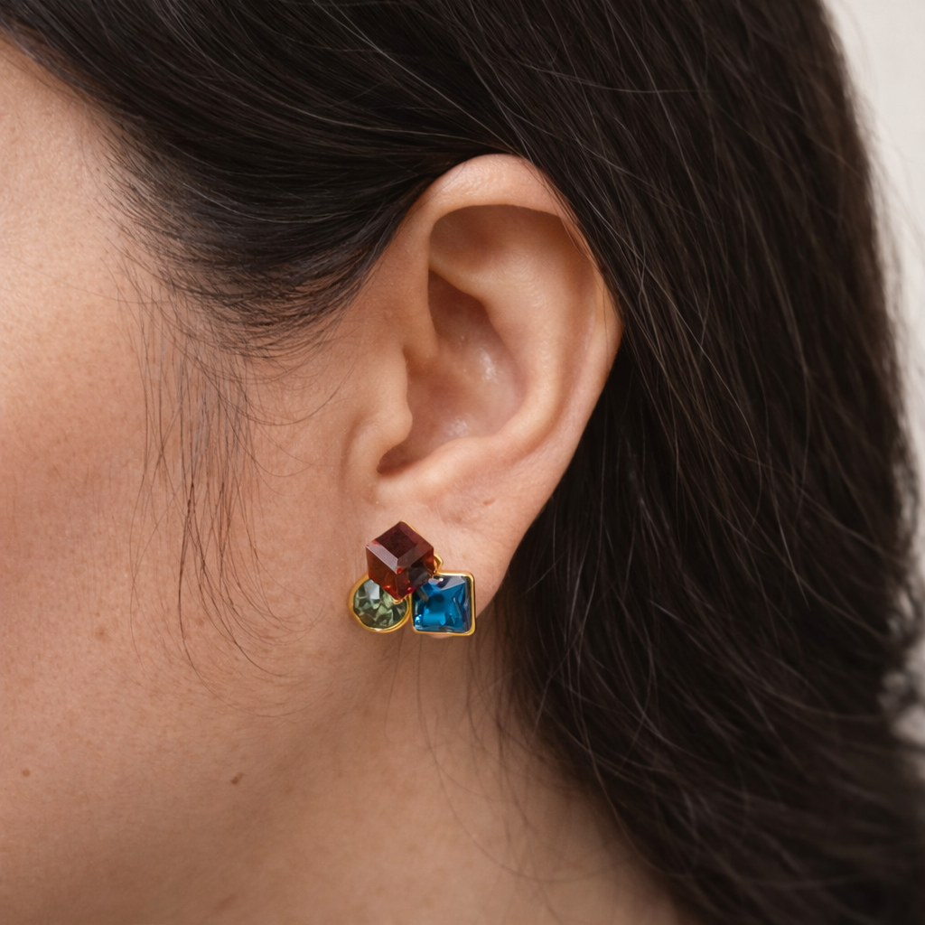 Gold plated geometric multi gemstone stud earrings worn by a woman in a clean everyday lifestyle setting
