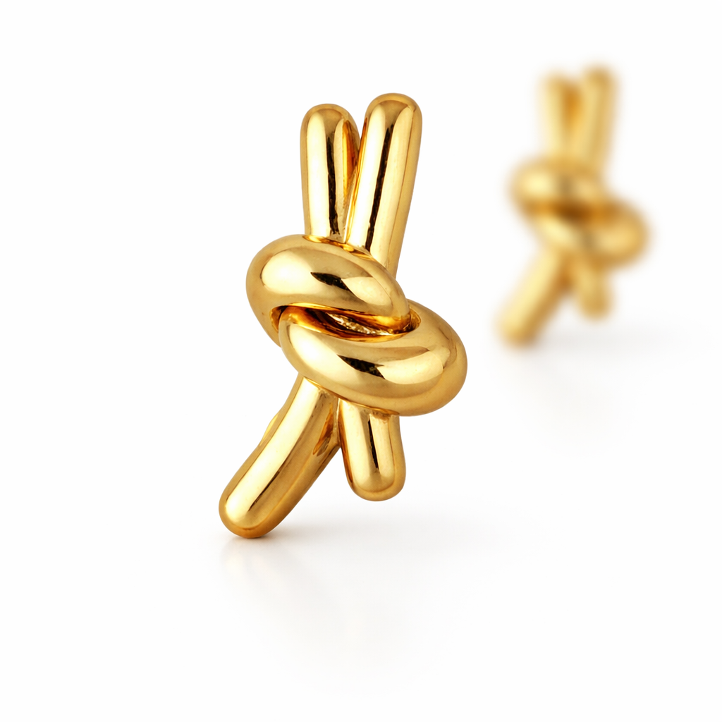 Gold plated knotted stud earrings with front earring in sharp focus and second softly blurred behind