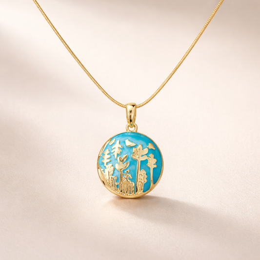 Gold necklace with a round pendant featuring nature-themed design on a beige background