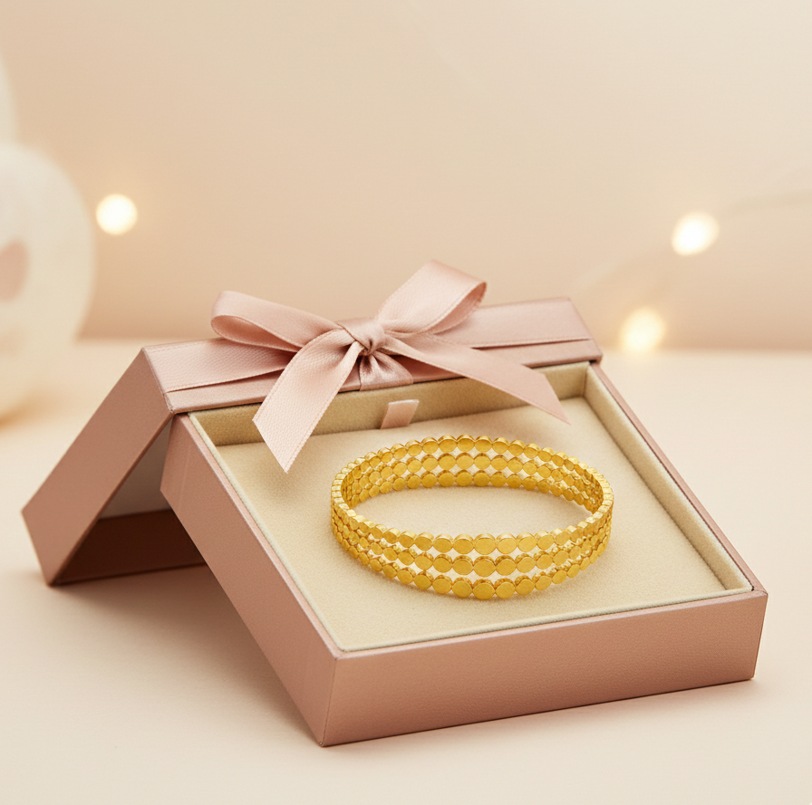 Gold bracelet in a pink gift box with a bow on a soft background