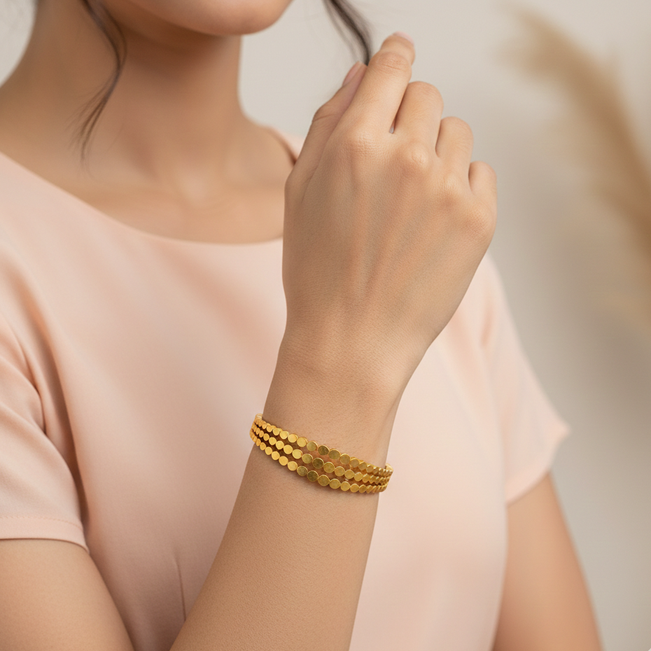 Gold bracelet on a women's wrist with a soft background